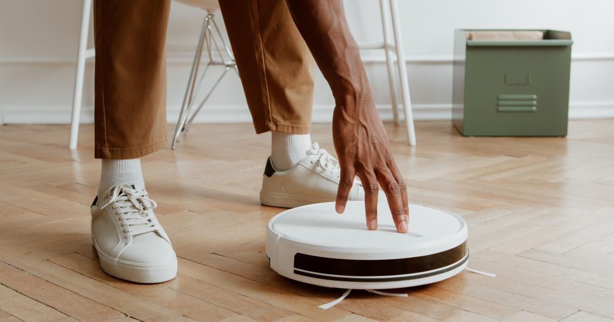 Robotický vysavač otočený dnem vzhůru na čisté lince s odkrytými kartáči