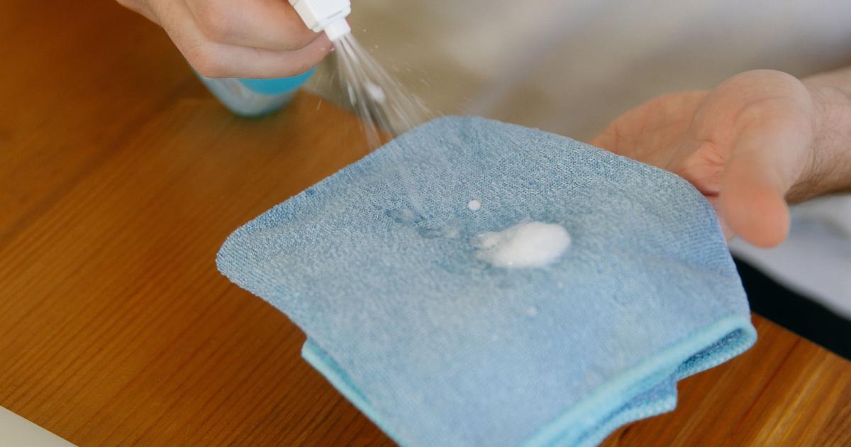 Žena otírající displej běžeckého pásu jemným hadříkem z mikrovlákna