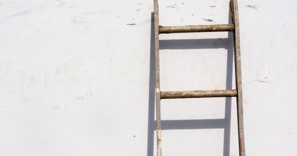 Osoba bezpečně stoupající po štaflích k vysokému stropnímu ventilátoru