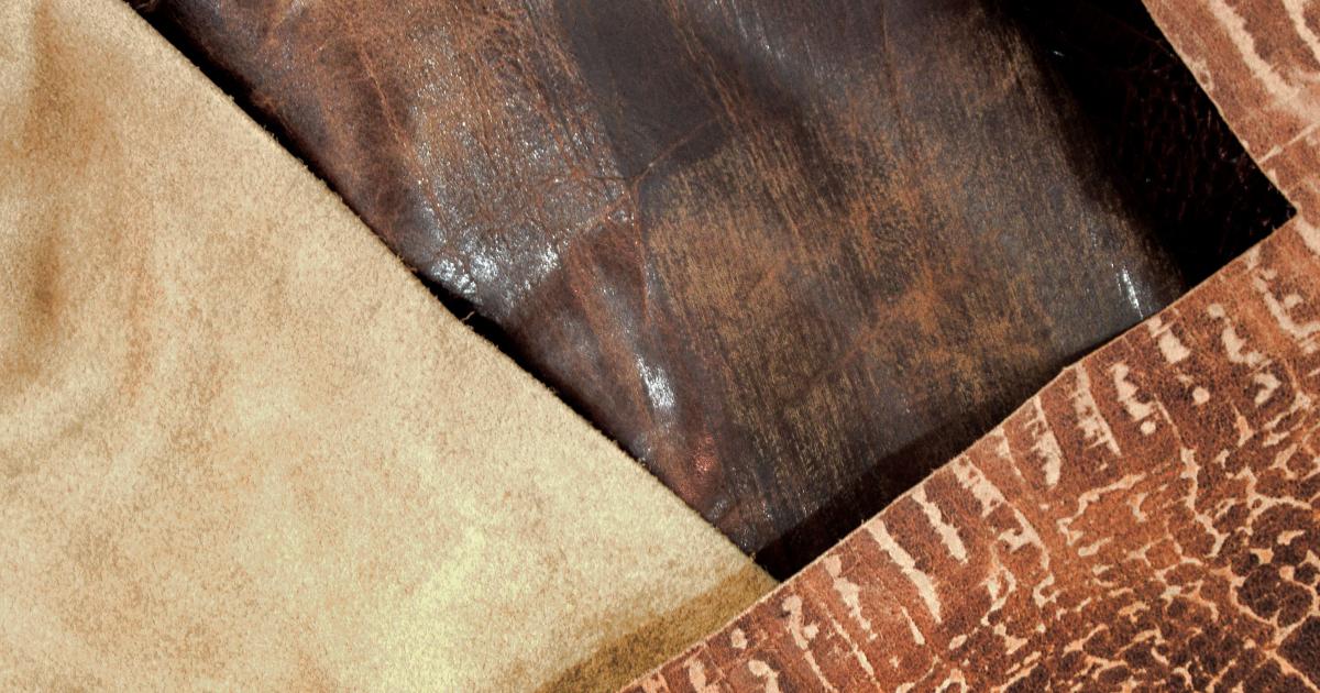 Detailní záběr na ruce, které jemným hadříkem opatrně otírají hnědou koženou kabelku