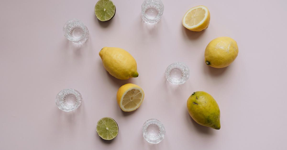 Čistá, světlá kuchyňská linka s lahví bílého octa a mísou čerstvých citronů