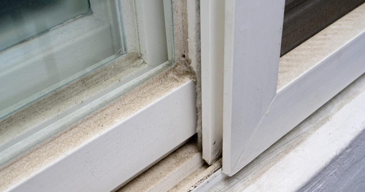 Detailní pohled na špinavou okenní drážku plnou prachu a nečistot