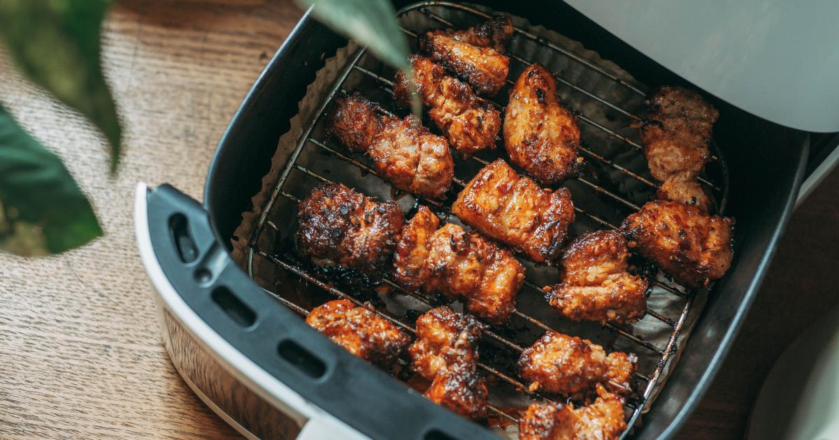 Detailní záběr na zubní kartáček jemně čistící kovové spirály topného tělesa horkovzdušné fritézy