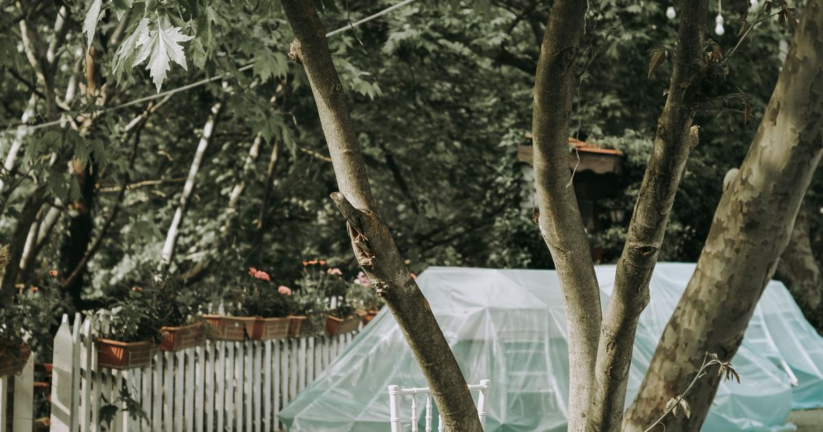 Čisté bílé plastové zahradní židle kolem dřevěného stolu