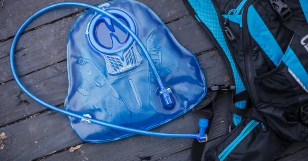 Modrý hydrovak visící dnem vzhůru na sušáku s odpojenou hadičkou